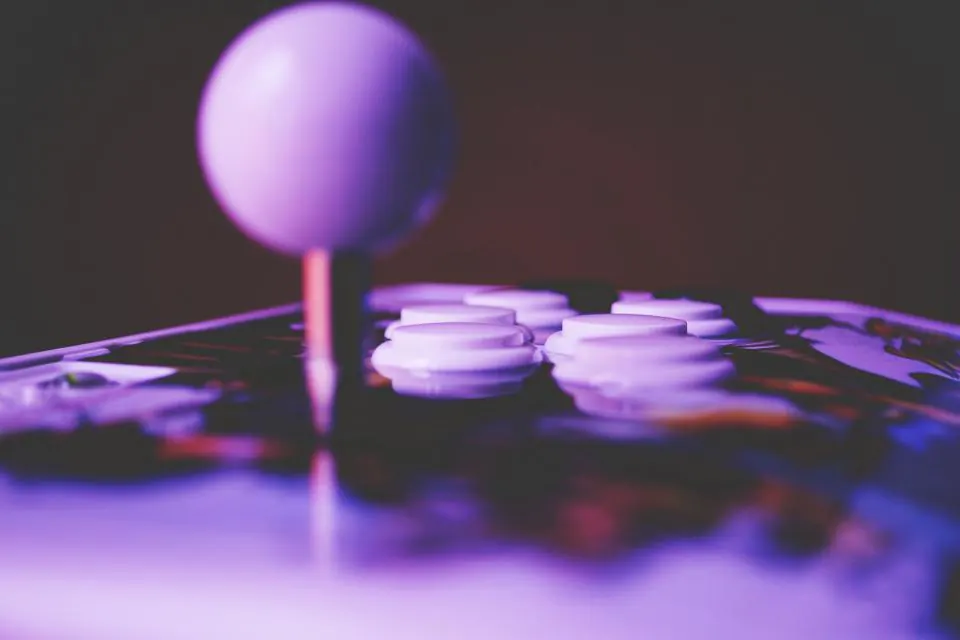 Botões e joystick de uma máquina de arcada iluminados a violeta